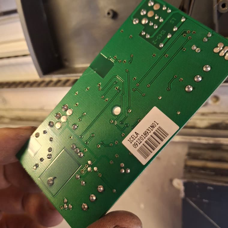 Scheda elettronica di una serranda tenuta in mano durante la riparazione